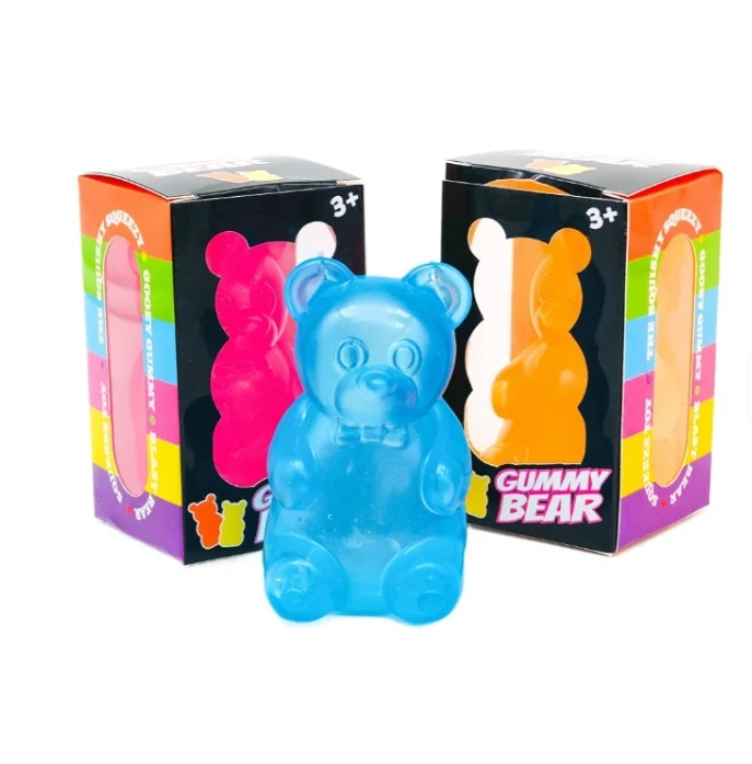 A blue squishy gummy bear in front of its gift boxes