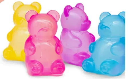 Yellow, pink, purple and blue squishy gummy bears sitting in a row